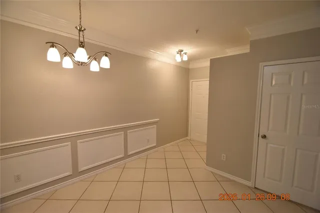 a view of an empty room with chandelier