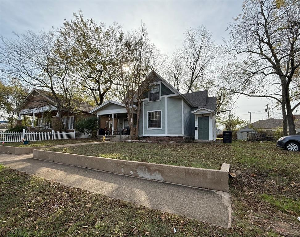 224 West Hull Street, Unit B Denison, TX 75020 - Photo 2 of 13 a view of a big house with a big yard and large tree