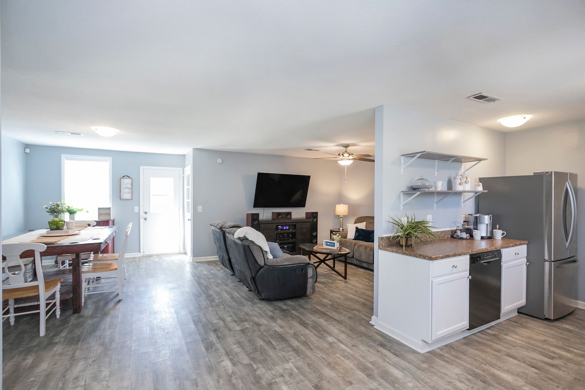 216 Warrior Road Madison, TN 37115 - Photo 8 of 37 a living room with stainless steel appliances furniture a flat screen tv and a wooden floor