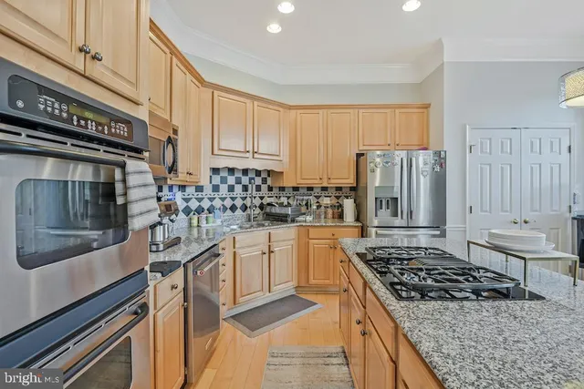 a kitchen with stainless steel appliances a stove a sink and a refrigerator