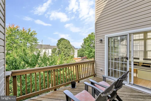 a view of a balcony with wooden floor and outdoor seating
