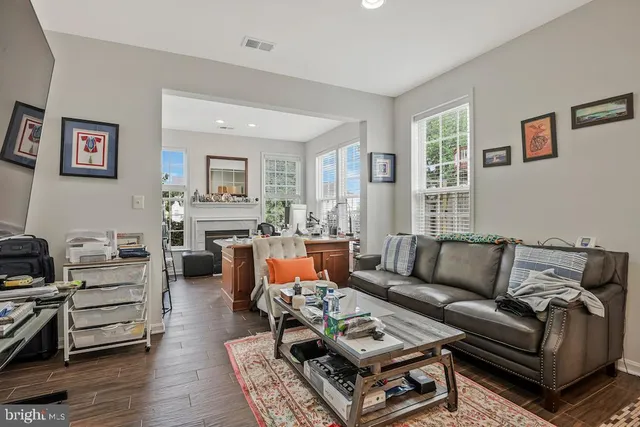 a living room with furniture fireplace and a large window