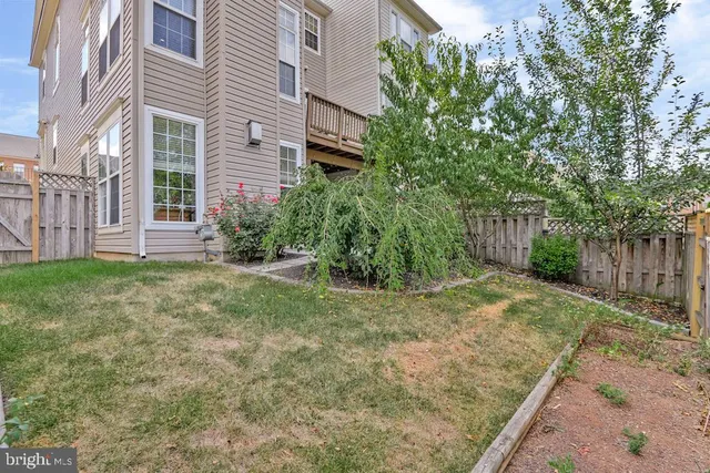 a view of a yard in front of a brick house with large windows