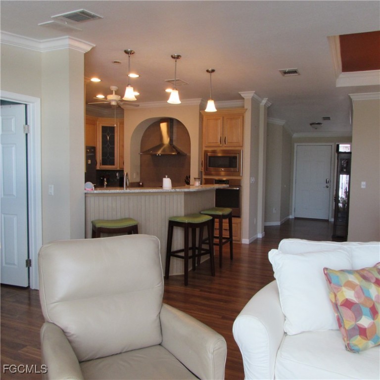 3083 Sloop Lane St. James City, FL 33956 - Photo 14 of 41 a living room with furniture a glass table and kitchen view
