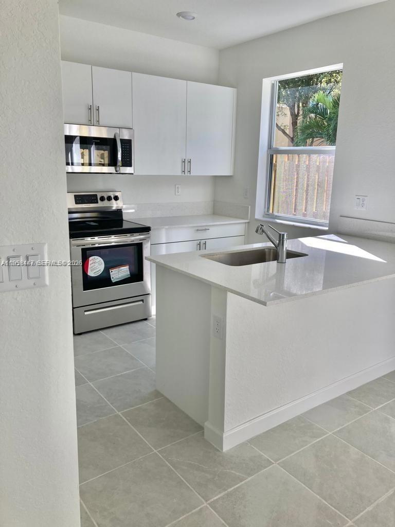 1070 Southeast 26th Street Homestead, FL 33035 - Photo 8 of 21 a kitchen with a sink and a stove top oven