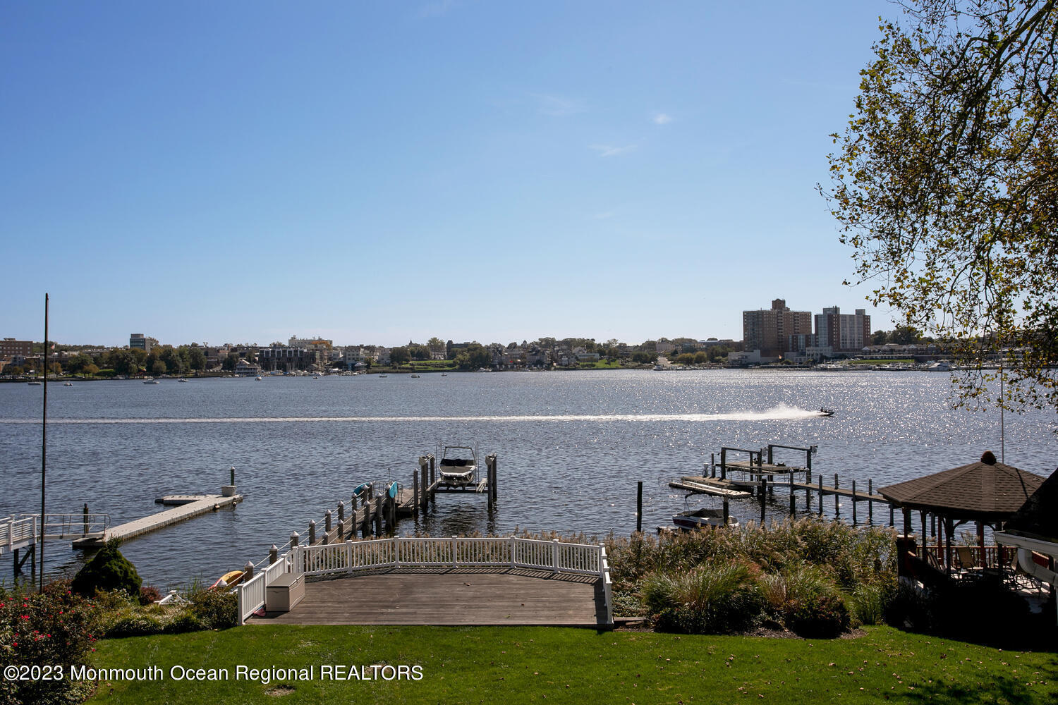 146 Conover Lane Red Bank, NJ 07701 - Photo 4 of 44 a view of a lake with couches and table and chairs under an umbrella