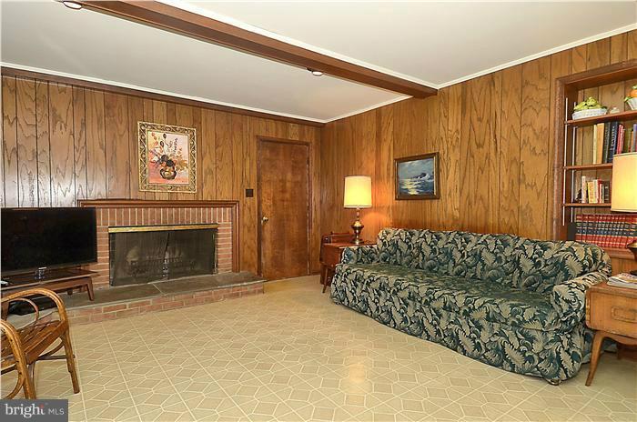 7700 Groton Road Bethesda, MD 20817 - Photo 9 of 30 a living room with a couch a fireplace and a flat screen tv