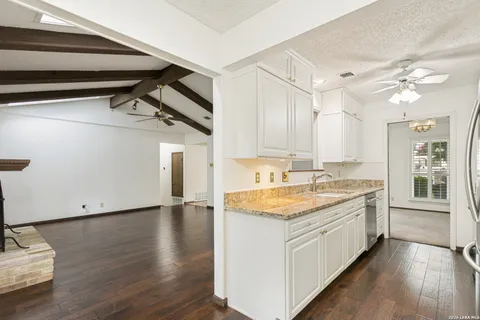 a kitchen with a stove and wooden floor