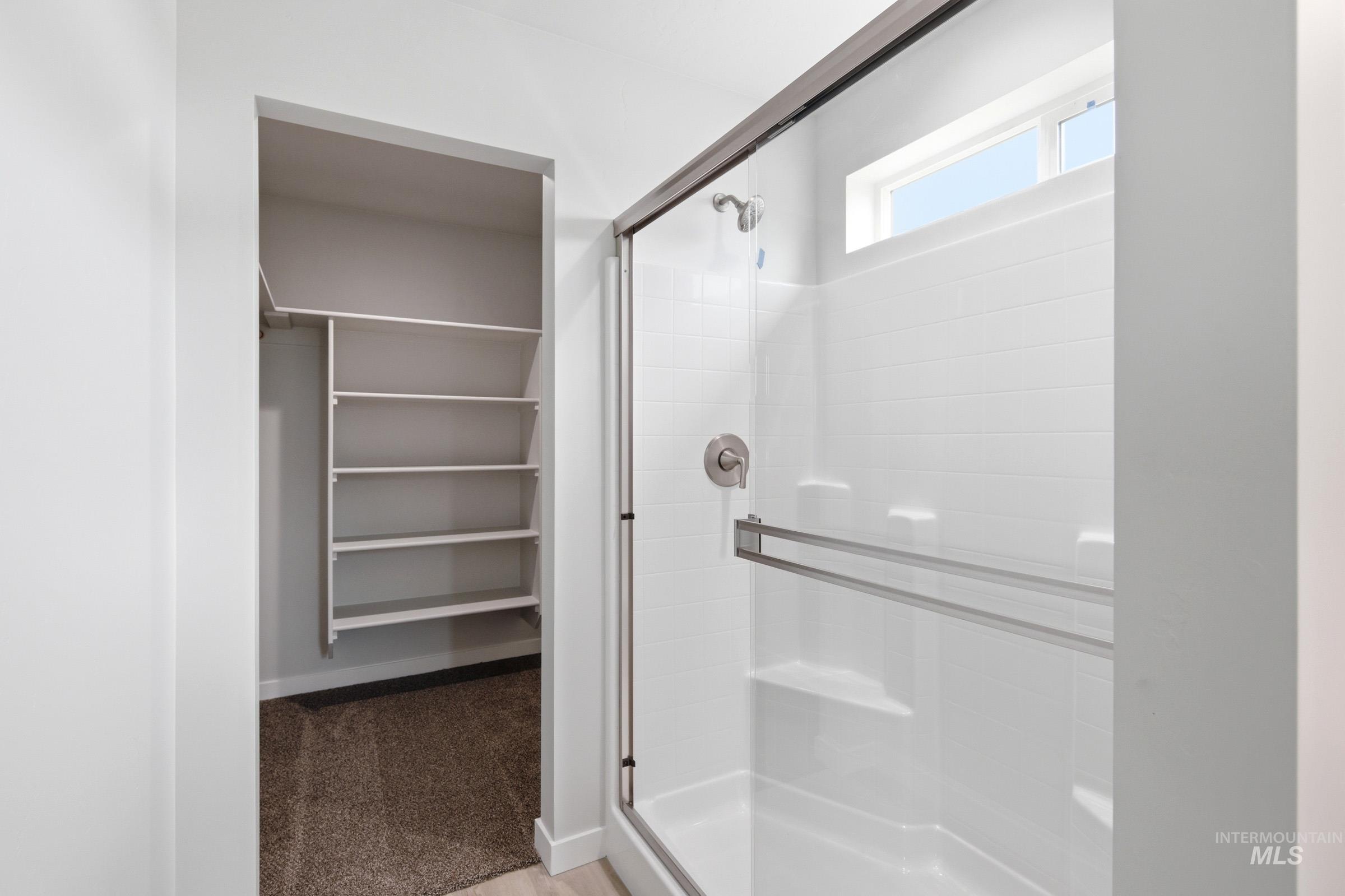 10770 Rutland Street Caldwell, ID 83605 - Photo 19 of 22 Shower with glass enclosure, brushed nickel fixtures, and a high transom window