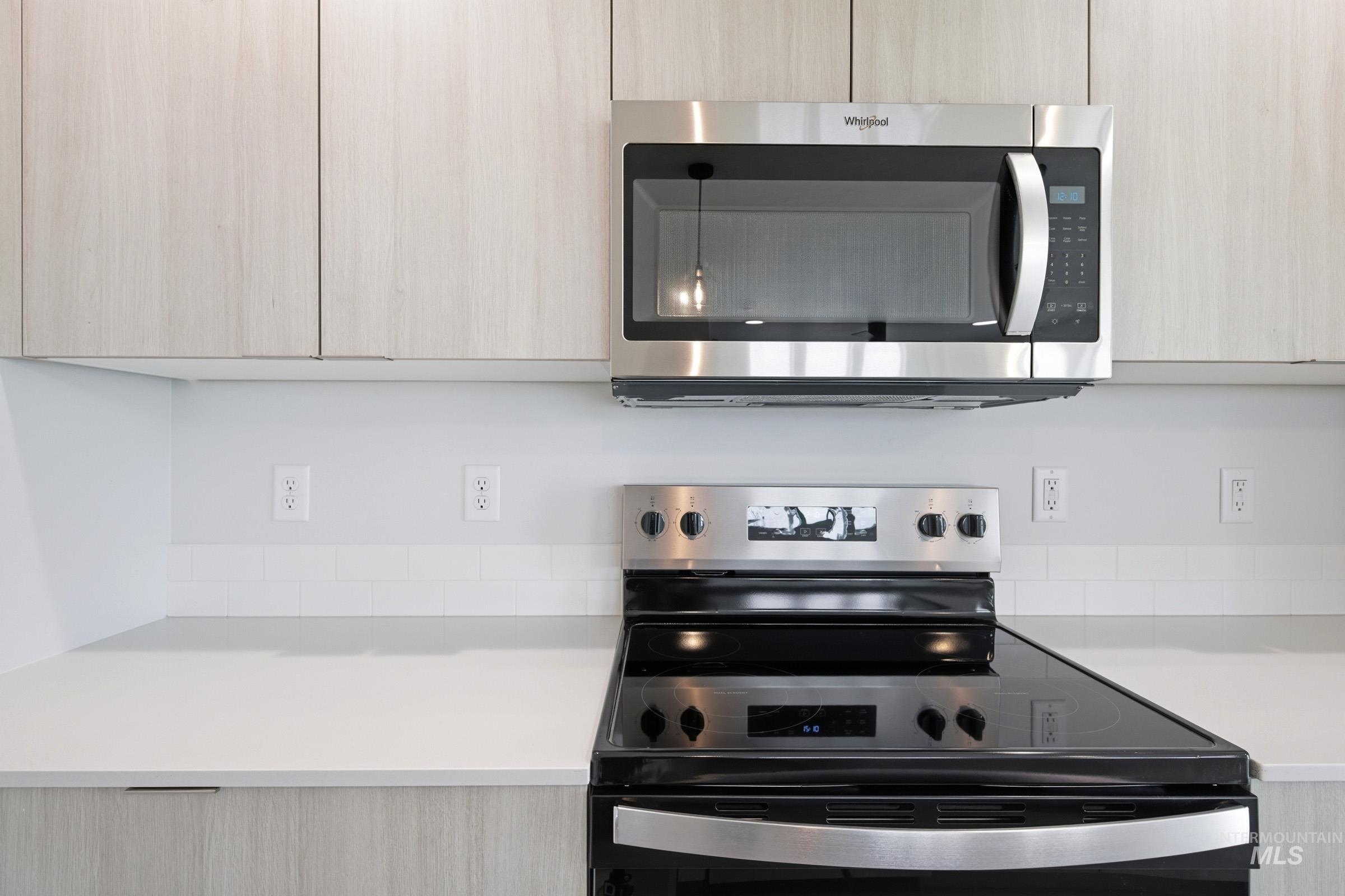 10770 Rutland Street Caldwell, ID 83605 - Photo 5 of 22 Modern kitchen featuring light wood-finish cabinetry, a white countertop, and a white subway tile backsplash