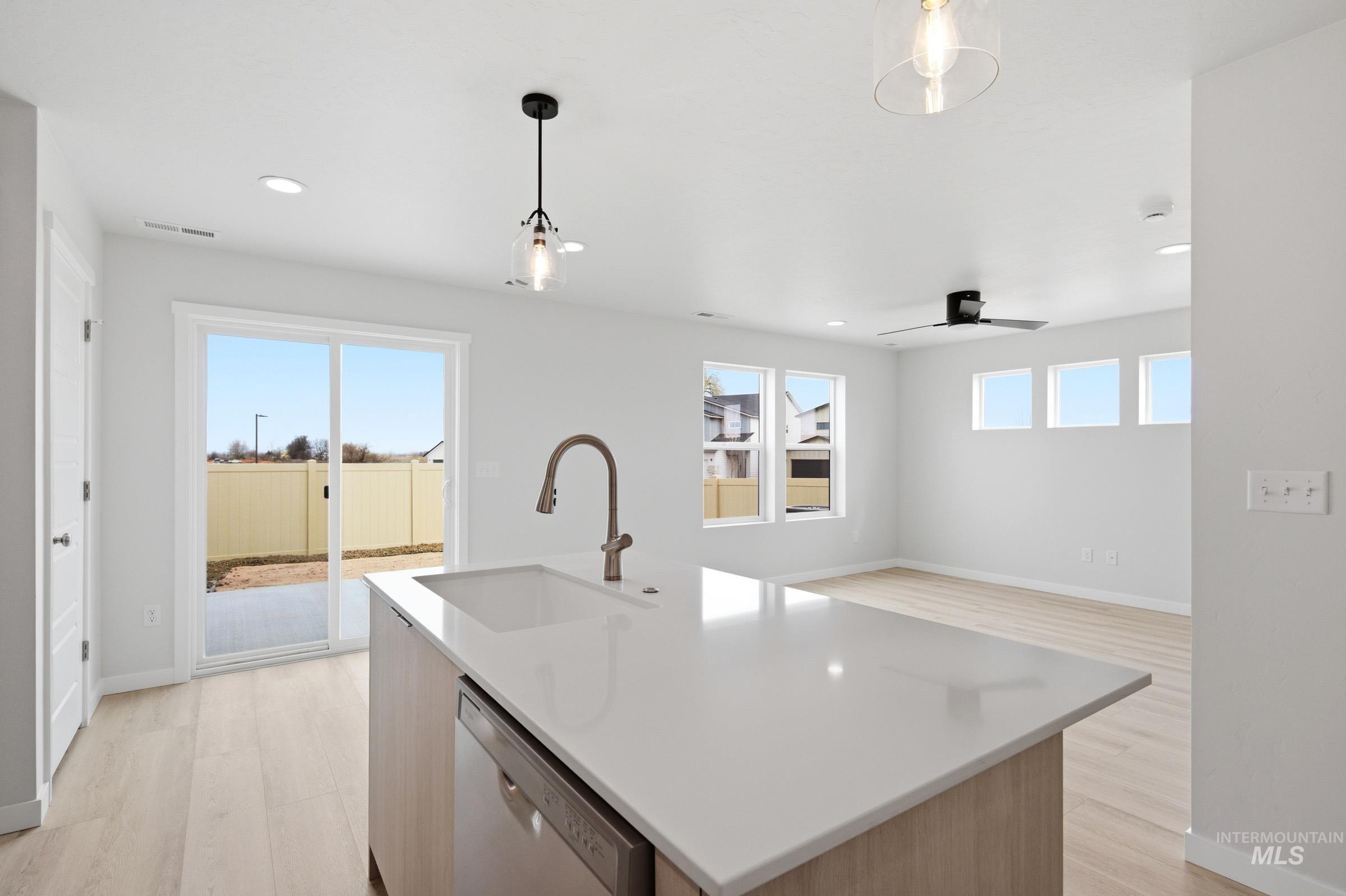 10770 Rutland Street Caldwell, ID 83605 - Photo 6 of 22 Spacious open-concept living area featuring an island with an undermount sink and a built-in dishwasher