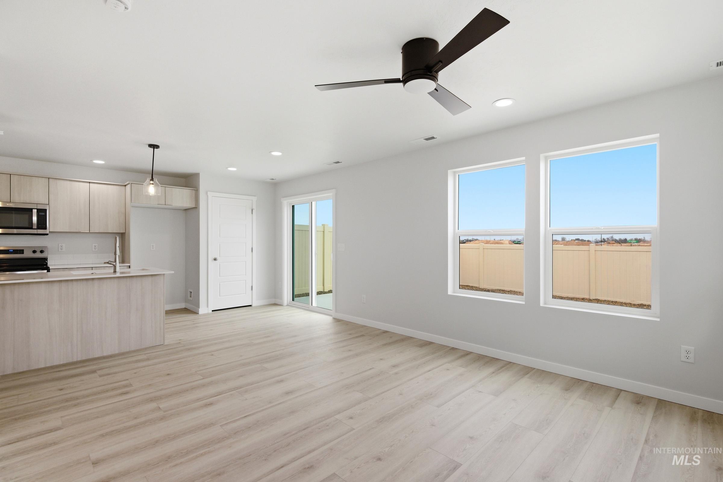 10770 Rutland Street Caldwell, ID 83605 - Photo 7 of 22 Open-concept living area featuring light wood-finish flooring, a contemporary ceiling fan, and recessed lighting