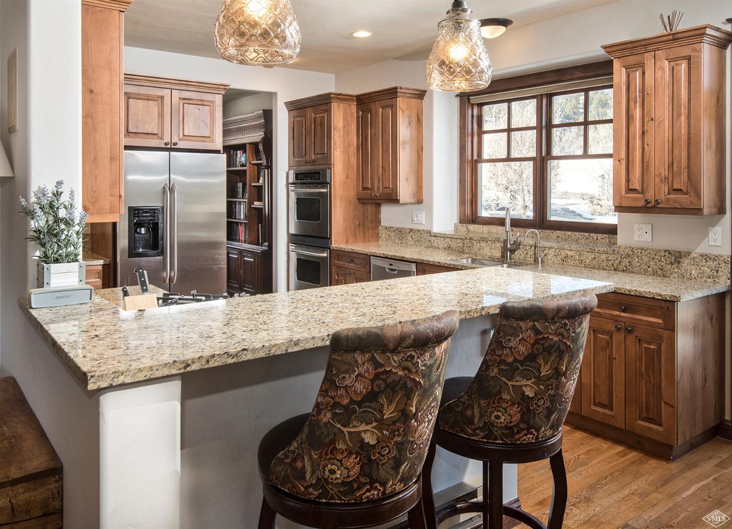 83 Newquist Street Eagle, CO 81631 - Photo 6 of 25 a kitchen with a granite countertop sink and wooden floor