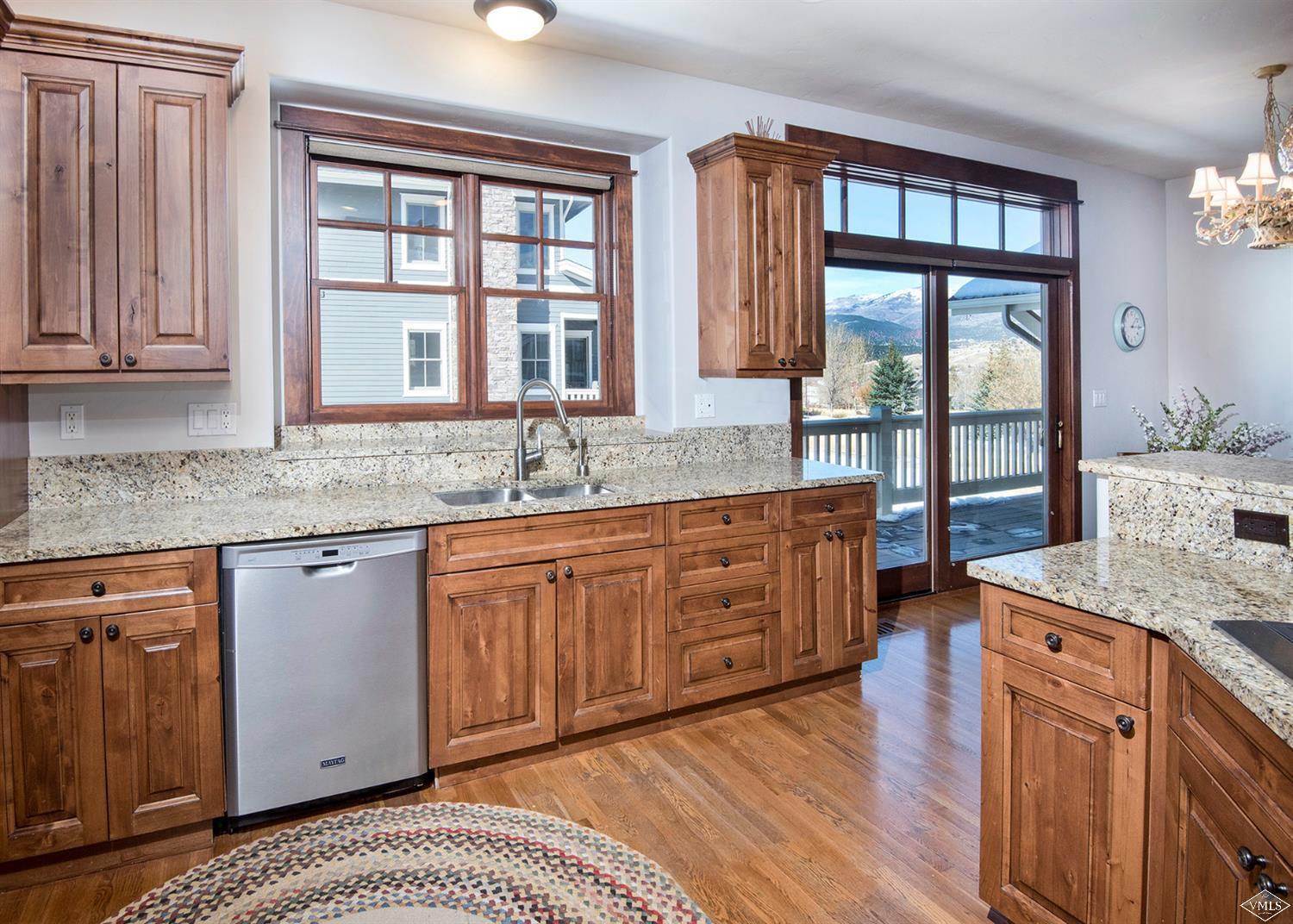 83 Newquist Street Eagle, CO 81631 - Photo 7 of 25 a kitchen with stainless steel appliances granite countertop wooden cabinets a sink and dishwasher with wooden floor
