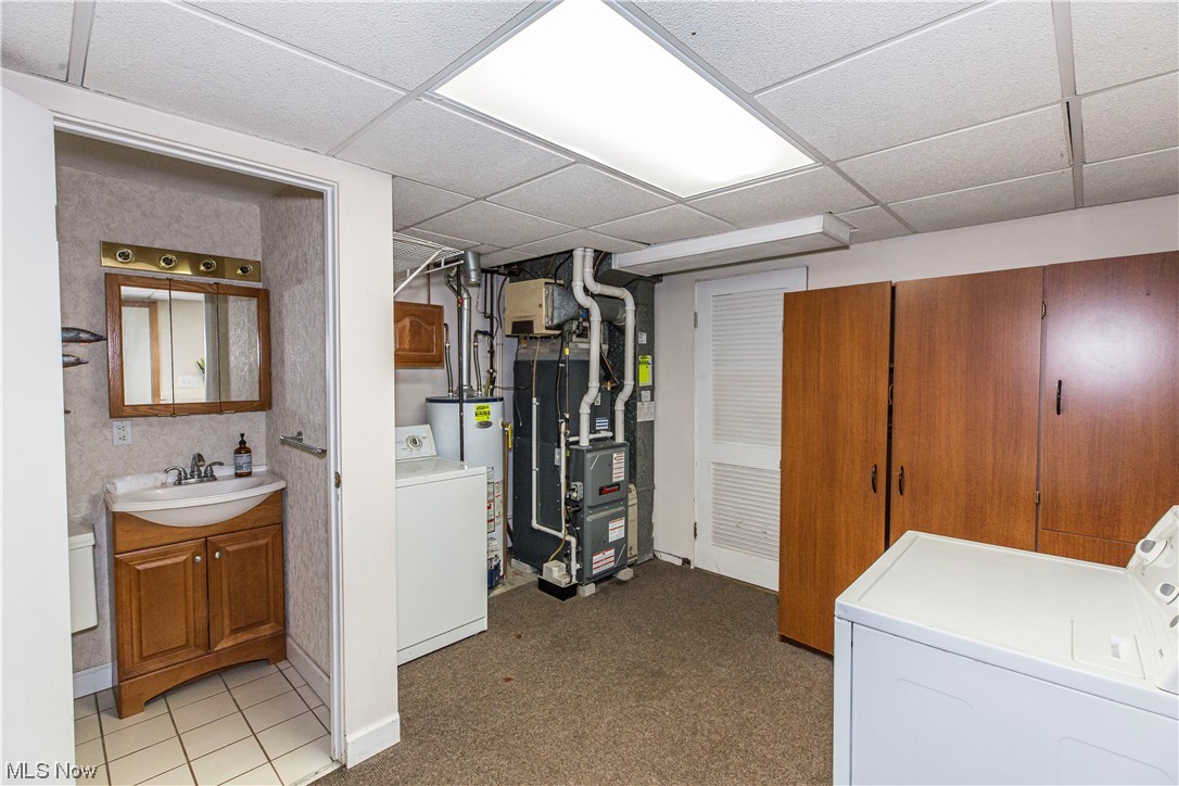 3755 North Santom Road Stow, OH 44224 - Photo 18 of 23 Basement with light tile floors, sink, washing machine and dryer, and a paneled ceiling