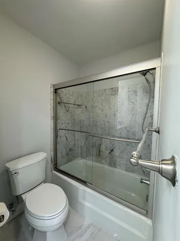 a bathroom with a toilet and a shower