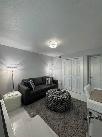 a living room with furniture a lamp and a window