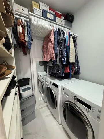 a view of walk in closet with clothes and shoes