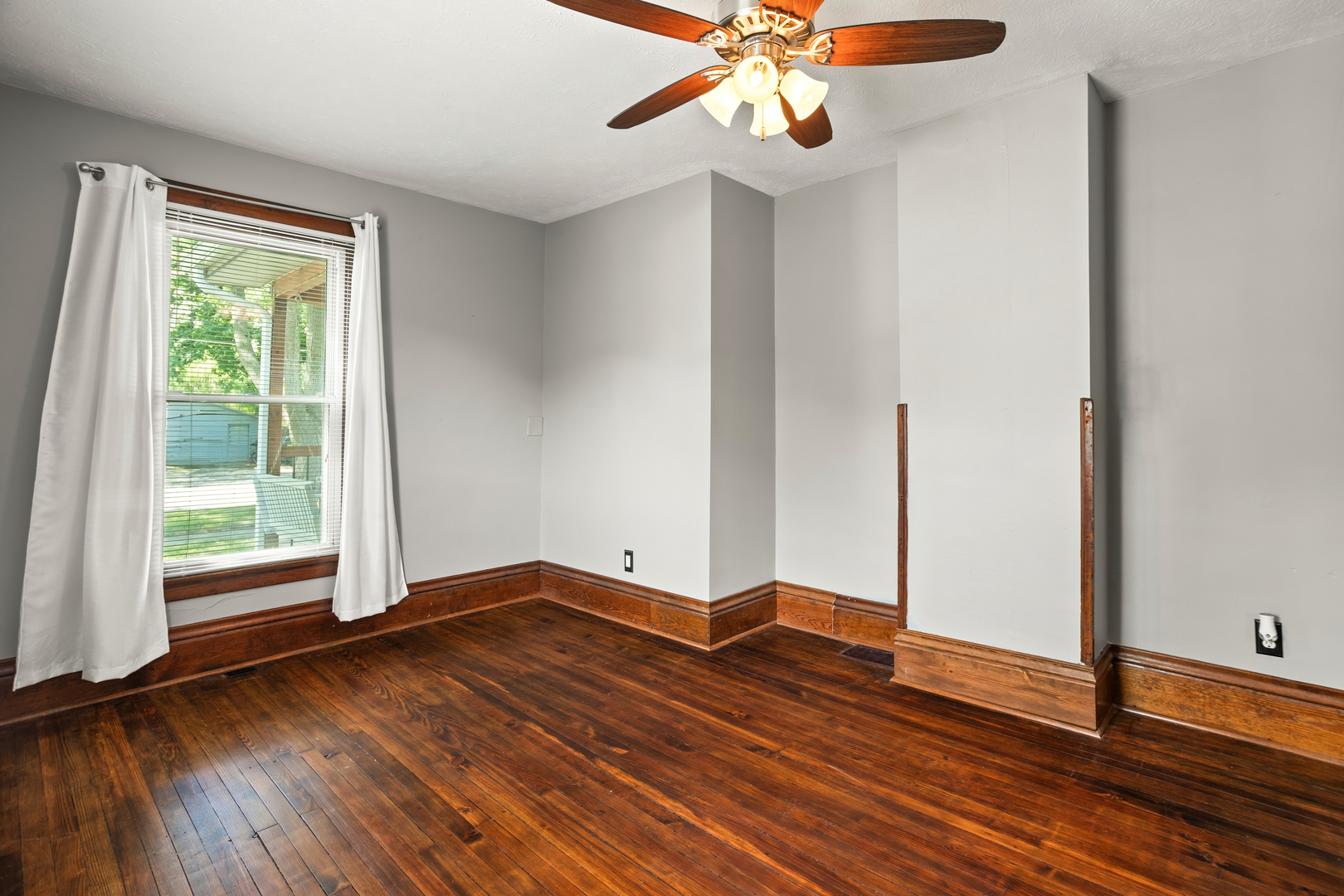 702 North Walnut Street Normal, IL 61761 - Photo 9 of 45 a view of an empty room with wooden floor and a window