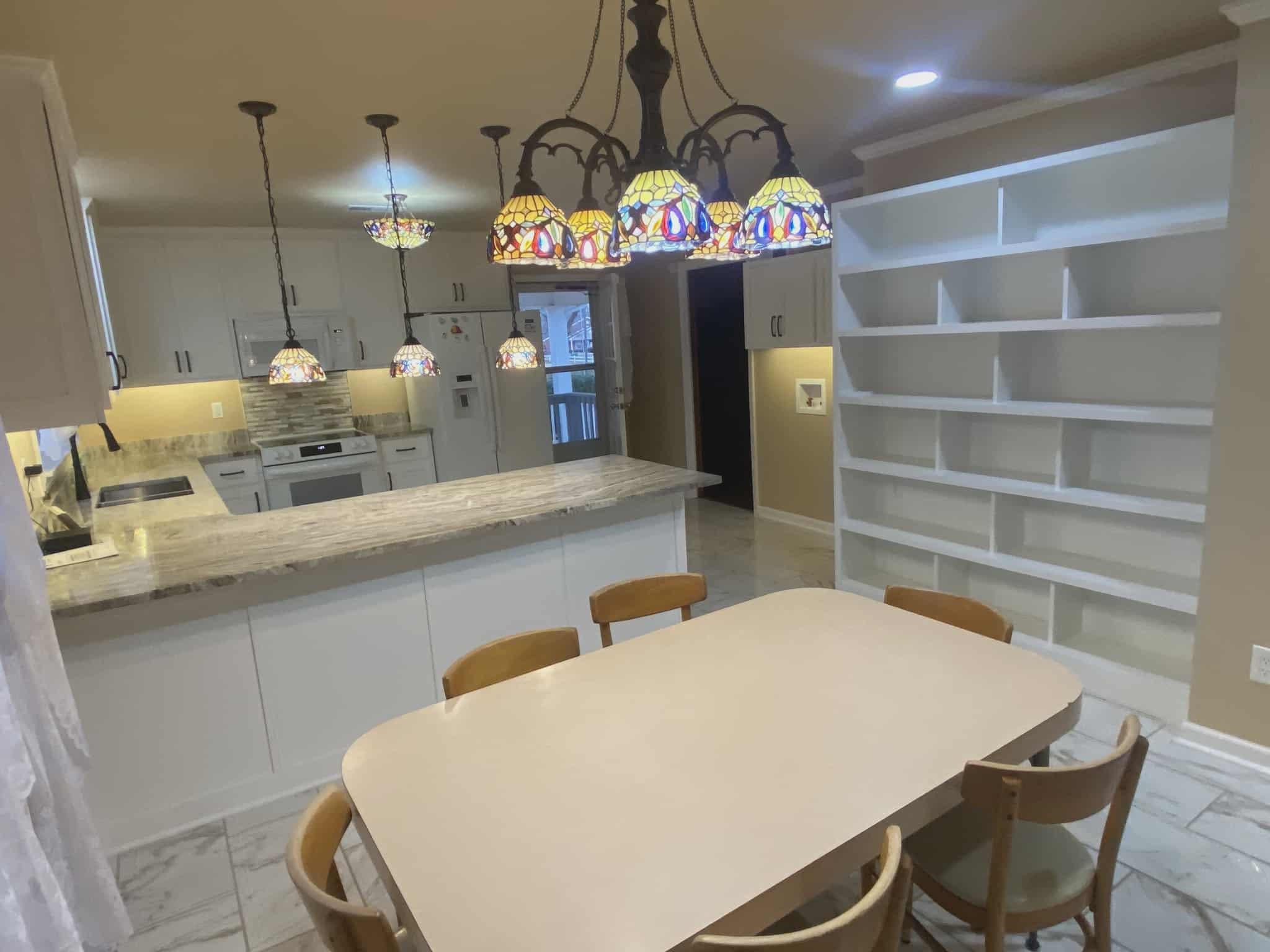 175 Austin Street Savannah, TN 38372 - Photo 6 of 33 a kitchen with a dining table chairs sink and white cabinets