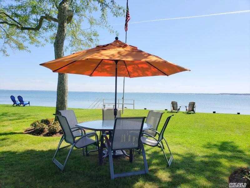 15 Downs Boulevard Jamesport, NY 11970 - Photo 2 of 25 a view of lawn chairs and table under an umbrella