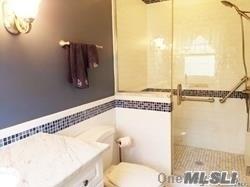 15 Downs Boulevard Jamesport, NY 11970 - Photo 21 of 25 a bathroom with a toilet and a bathtub