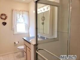 15 Downs Boulevard Jamesport, NY 11970 - Photo 23 of 25 a bathroom with a granite countertop sink toilet and shower