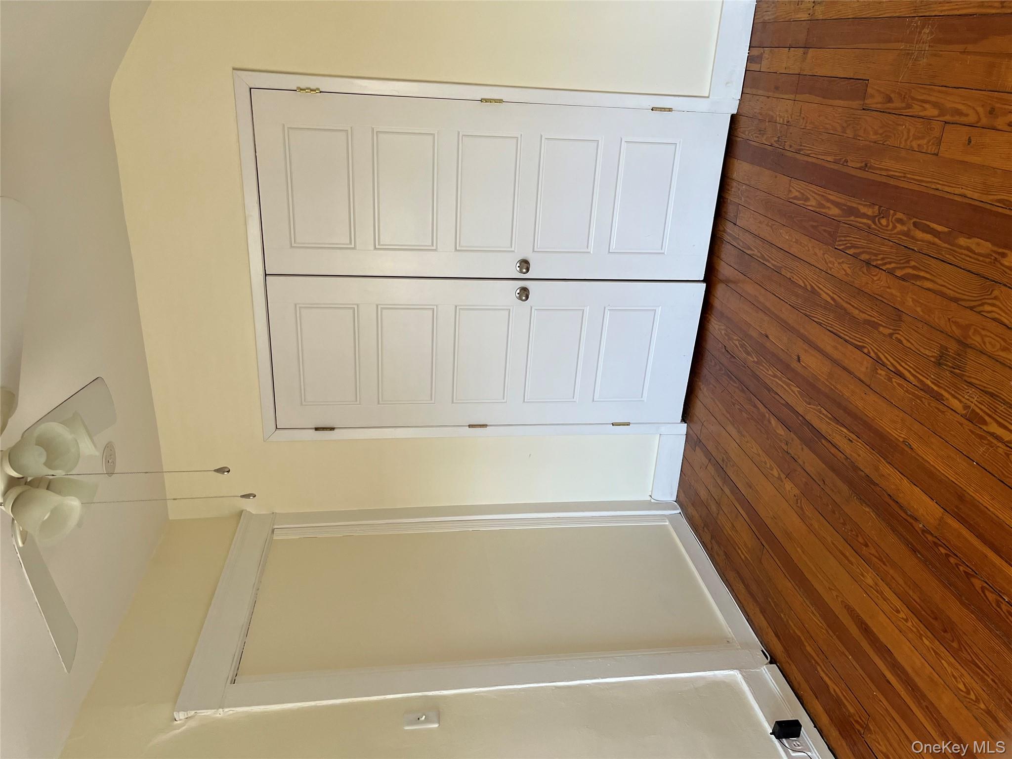 51 Parkway Road, Unit 3 Bronxville, NY 10708 - Photo 14 of 20 an empty room with wooden floor and cabinet