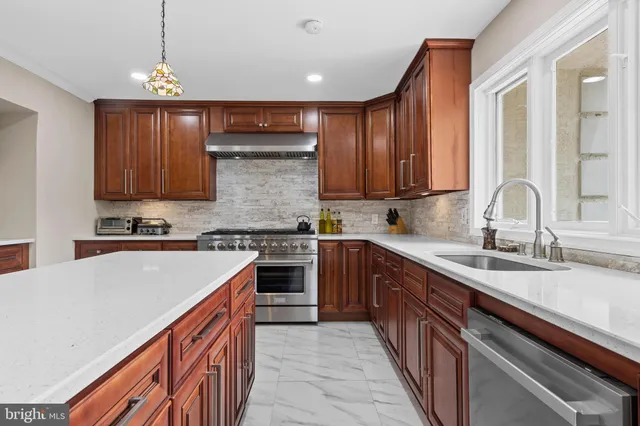 a kitchen with granite countertop a sink stainless steel appliances and cabinets