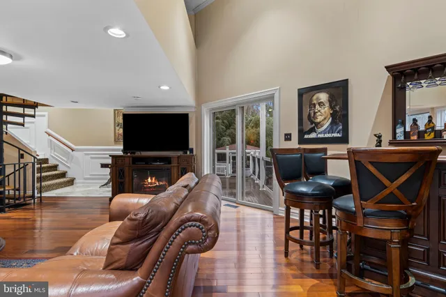 a living room with furniture a flat screen tv and a floor to ceiling window