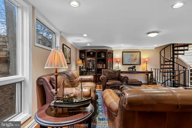 a living room with furniture a flat screen tv and a floor to ceiling window