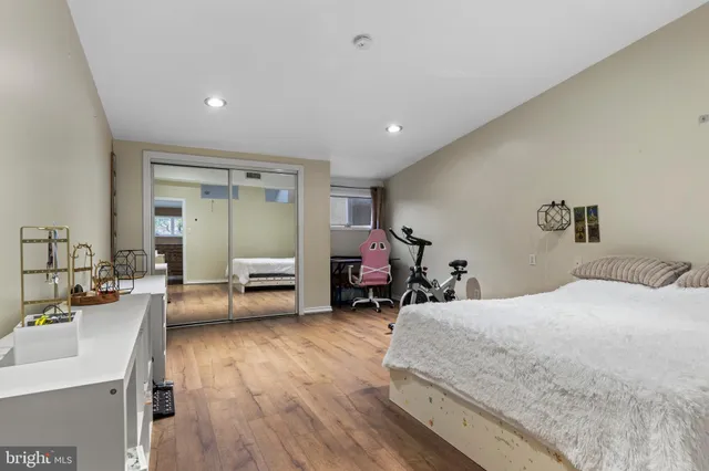 a spacious bedroom with a bed and wooden floor