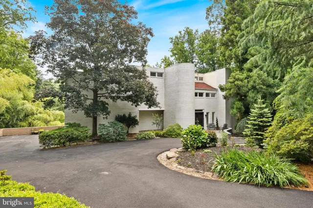 a aerial view of a house with a yard and large trees