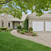 a front view of a house with a garden and plants