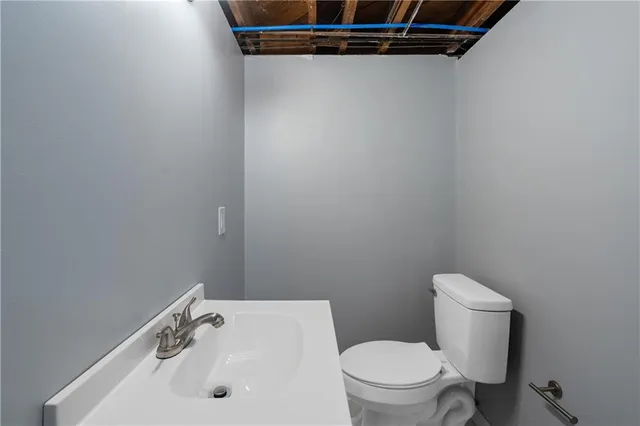 a white toilet sitting next to a white sink