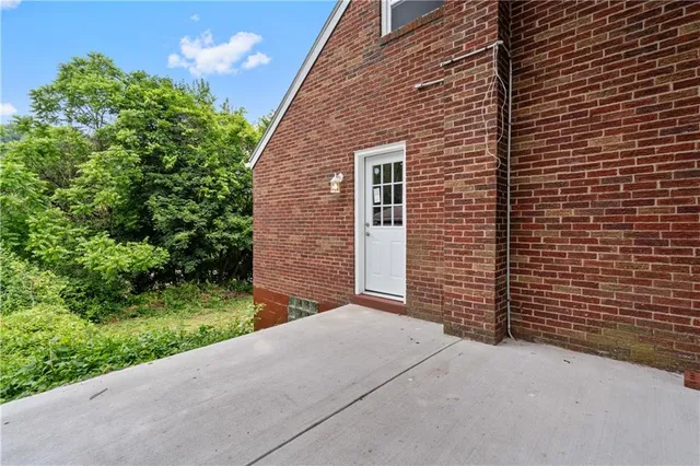 a view of a brick house with a small yard