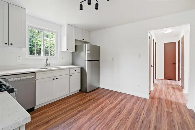 a kitchen with a sink wooden floor and a window