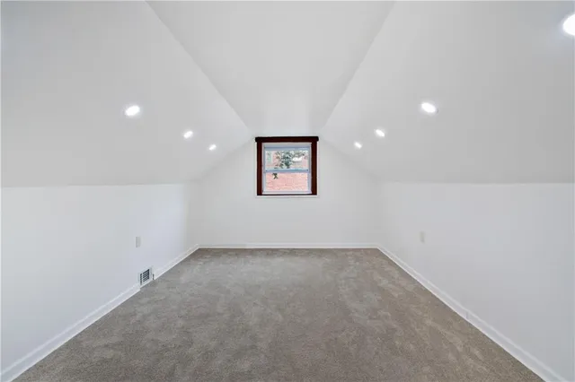 an empty room with a hallway and a painting