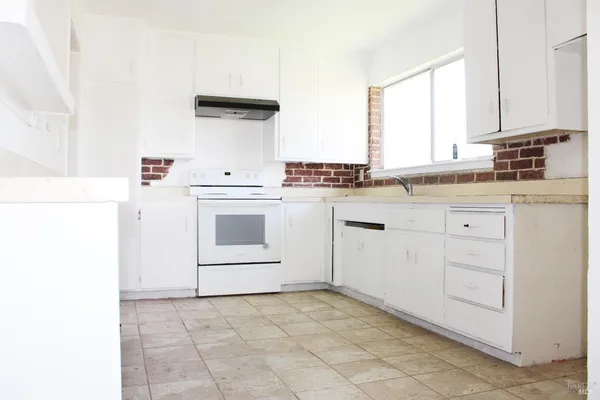 a kitchen with a stove a sink and a refrigerator
