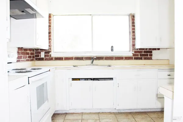 a kitchen with a sink cabinets and a window