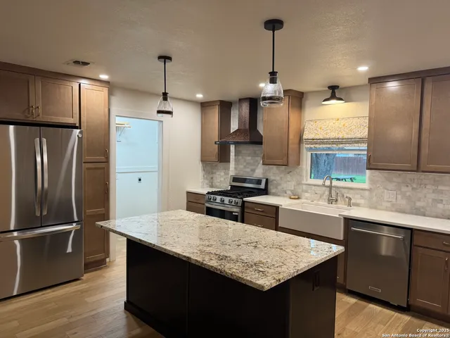 a kitchen with stainless steel appliances granite countertop a sink refrigerator and microwave