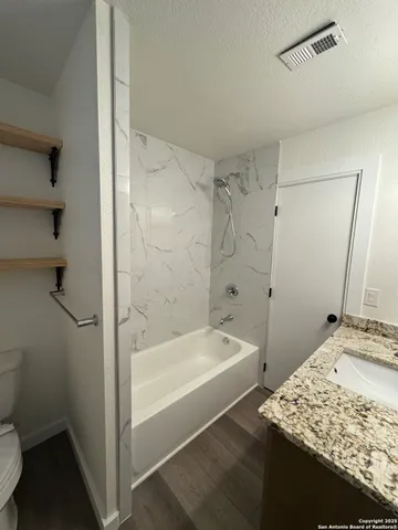 a bathroom with a white bath tub and a shower