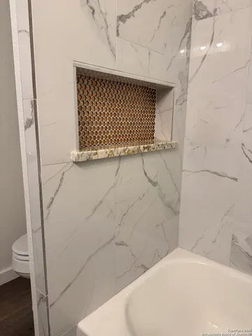 a bathroom with a granite countertop sink vanity and mirror