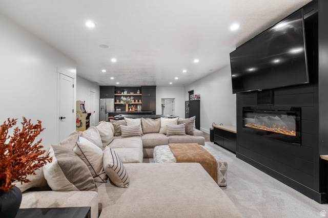 1276 West Fallow Way, Unit 76 Ogden, UT 84414 - Photo 5 of 22 Living room featuring light colored carpet, recessed lighting, a fireplace, and bar