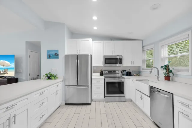 a kitchen with white cabinets and stainless steel appliances