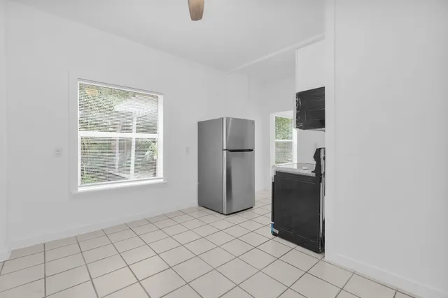 a room with a window and a refrigerator