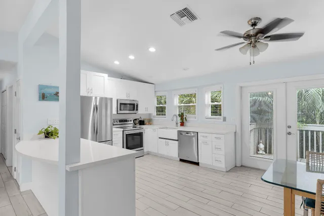 a kitchen with white cabinets and stainless steel appliances