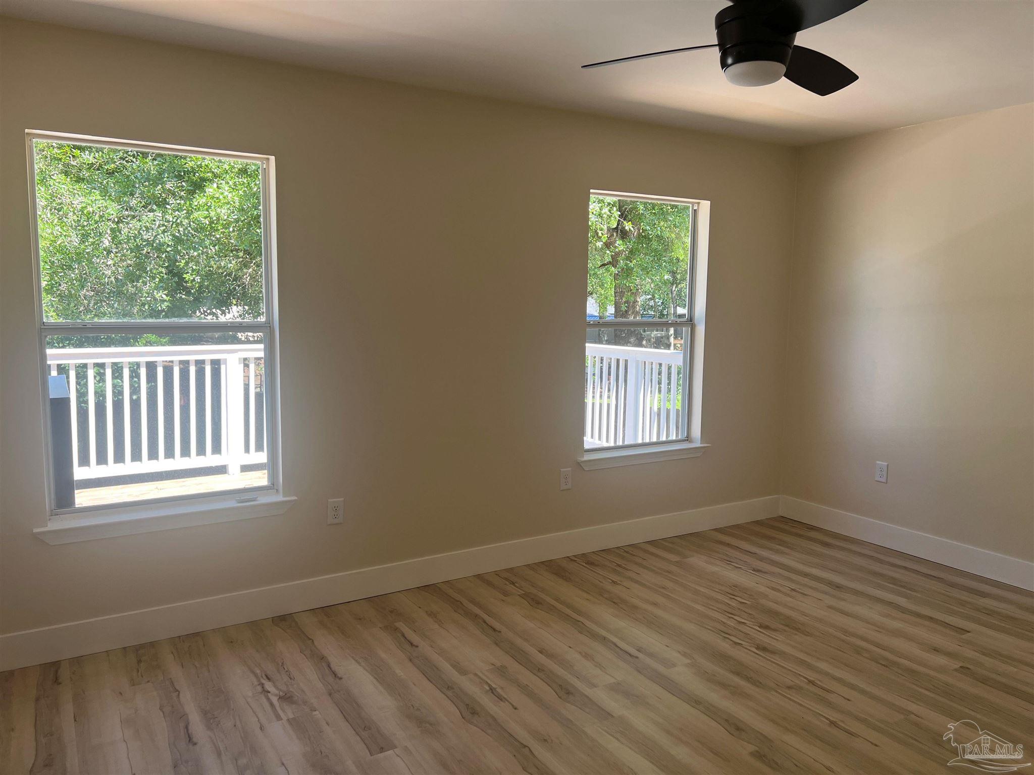 3111 Holley Point Road Navarre, FL 32566 - Photo 8 of 23 a view of an empty room with wooden floor and a window