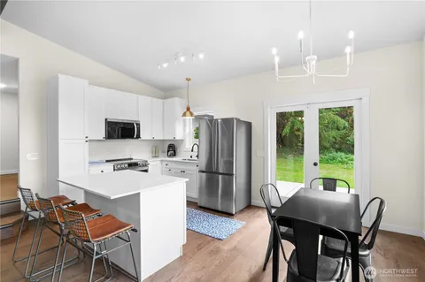 a kitchen with refrigerator a chair and wooden floor