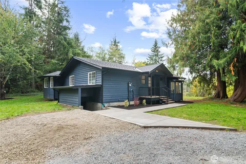 a view of a house with a yard and large tree